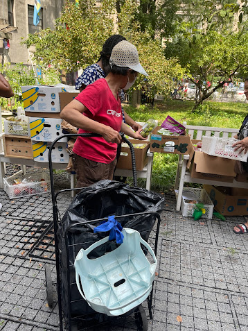Volunteers handing off supplies and speaking with neighbors during an outreach day